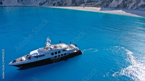 Aerial drone photo of luxury yacht anchored in paradise beach of Myrtos with crystal clear turquoise sea surrounded by steep cliffs, Kefalonia island, Ionian ,Greece