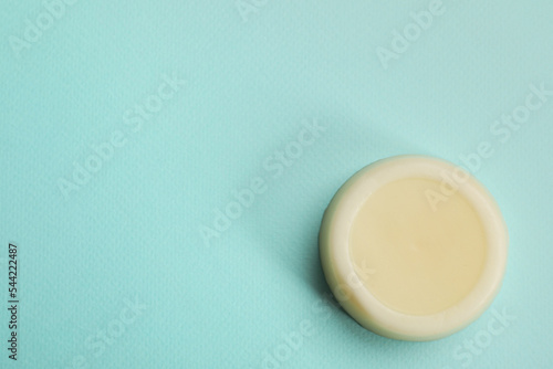 Solid shampoo bar on turquoise background, top view. Space for text