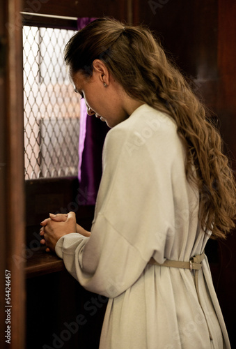 Christian woman, church and confessional, worship and prayer for forgiveness, mercy and peace to holy God, praying and faith. Spiritual person in booth, sorry about sin, secret and trust to priest