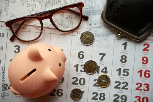 paragony fiskalne , polskie monety, kartka z kalendarza, świnka skarbonka, emerytura
