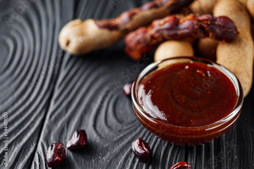 sweet and sour tamarind sauce on a black rustic wooden background