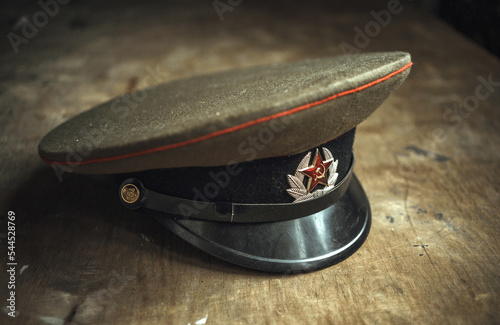 The cap of a Soviet soldier on a wooden table. A cockade with a red star. Tank officer's cap.