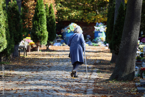 Polski cmentarz w czasie święta zmarłych odwiedzają starsi ludzie.