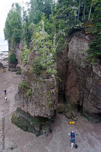 Fundy National Park, New Brunswick, Canada: Tourists stand near a fallen rock area at the Hopewell Rocks on the Bay of Fundy at low tide.
