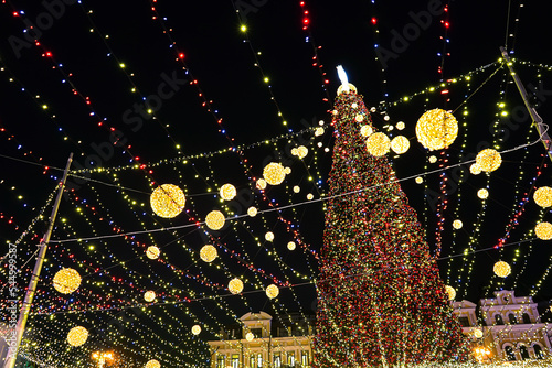 Holiday lights of the city Christmas tree at night on central city square, Kyiv, Ukraine. Shining holiday decorations. Night, evening illumination. New Year background, Christmas celebration outdoor