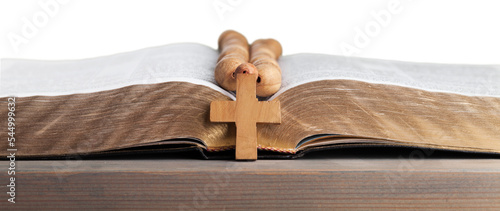 Rosary beads on open bible on wooden table