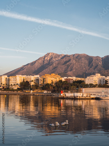 Beautiful sunrise of the city of Marbella (Costa del Sol, Spain) with its beach and its mountain in the background with a clear sky
