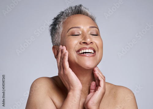 Beauty, face and happy mature woman, glowing skincare and dermatology of anti aging cosmetics on grey studio background. Smile, joy and wellness of lady model with confidence, happiness and self care
