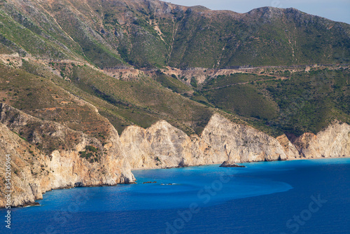 Top close up view at Assos peninsula cliffs and blue Ionian Sea water. Aerial view, summer scenery of famous travel destination in Cephalonia, Greece, Europe.