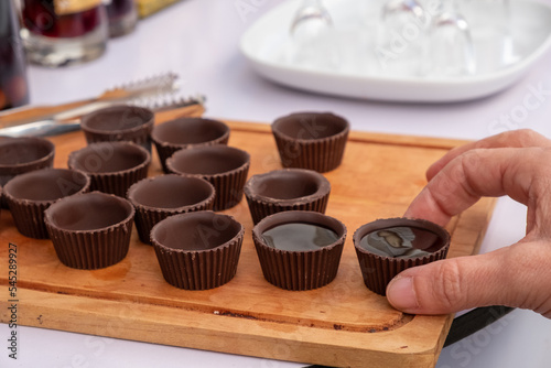 Men hand picking the traditional Ginja de Obidos, traditional sour cherry liqueur, served in small cups made of chocolate. Obidos, Portugal
