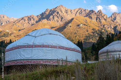 Kazakh guest yurt on the background of mountains not far from Almaty in early autumn. A beautiful landscape with a traditional nomad house in the mountains of Almaty.