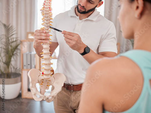 Chiropractor, spine and anatomy with a medical skeleton for advice and diagnosis of injury during physiotherapy with therapist and patient. Man talking to woman for chiropractic and physical therapy