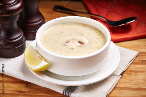 Hot Mushroom Soup with lime slice served in a bowl isolated on table side view of middle east food