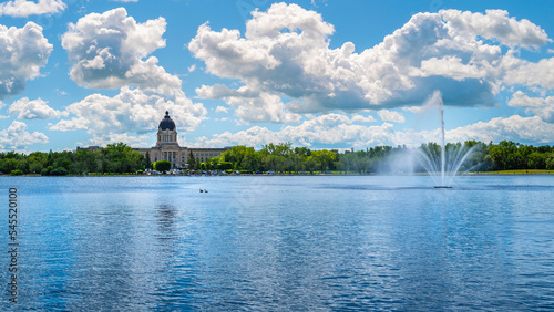 Wascana Park panoramic landscape with lake, fountain and Saskatchewan Legislative Building in Regina Saskatchewan Canada
