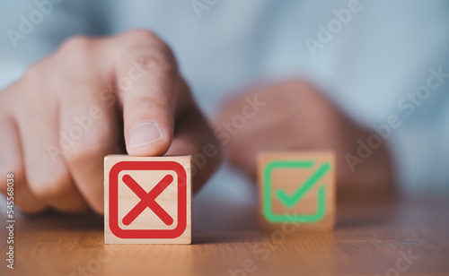 Hand push red Red Cross mark to choose cancellation item , Approve and reject business and document concept.