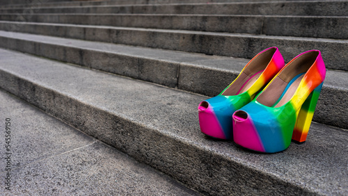 Drag queen in her colorful clothes strolls through the city listening to music and drinking coffee