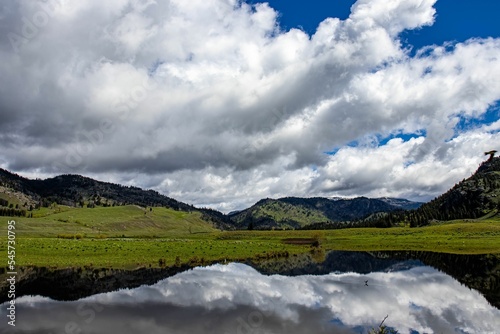 Low-angle of Yellowstone national park view with a lake reflecting cloudy sky and mountains