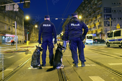 Policjant przewodnik psa podczas zabezpieczenia imprezy masowej.
