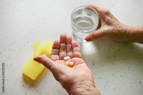 Taking medication - close-up of an elderly person's hand with pills