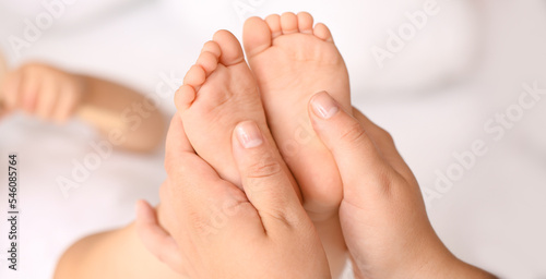 Mother massaging her baby's feet, closeup
