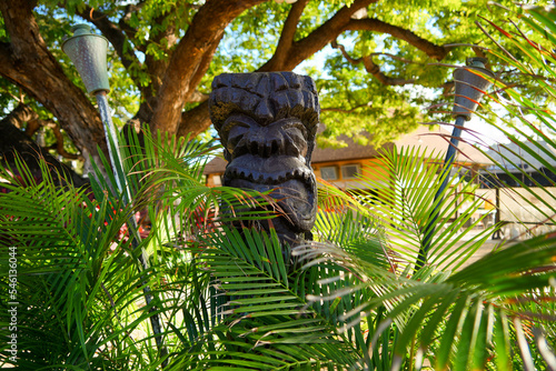 Kapolei, Hawaii / February 23, 2022 : Wooden statue of a tiki god at the Paradise Cove Luau in Ko Olina, a touristic area on the western shore of O'ahu island in Hawaii, United States