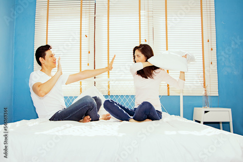 Playful asian couples use pillow fights on their mattresses because they resent something that men do not indulge and do as their girlfriend orders to make stupid women fight but men give up. 