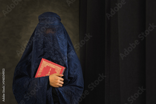 Asian women with burka reading the Islamic Quran