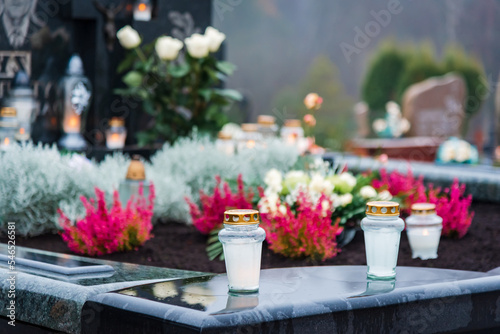 All Saints' Day and burning candles and flowers on the graves.Candles on graves symbolize the memory of the dead on November 1.Catholic cemetery during All Saints' Day.Selective focus.