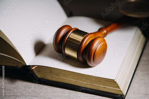 Justice and law concept.Male judge in a courtroom with the gavel, working with, computer and docking keyboard, eyeglasses, on table in morning light