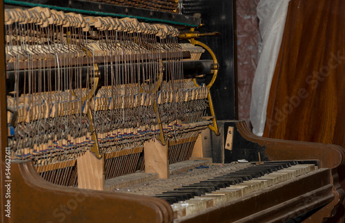 Stare , zabytkowe i zdewastowane pianino . Anatomia pianina - widoczna wewnętrzna budowa strunowego instrumentu .
