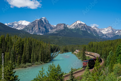 Freight train makes its way through Morants Curve in Banff National Park in the Canadian Rockies on a summer day