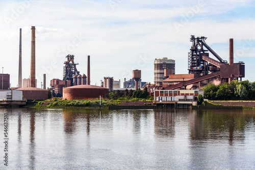 Integrated steelworks on the bank of a river on a partly cloudy summer day