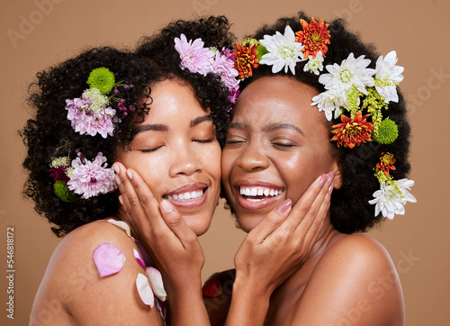 Flower, skincare and African women with support for wellness from dermatology against a brown studio background. Beauty, care and floral model friends with love for flowers and cosmetics with a hug