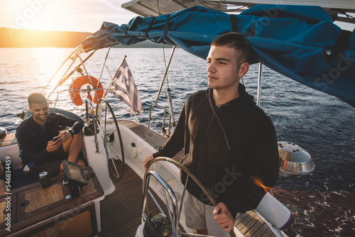 Young man at the sailboat helm 