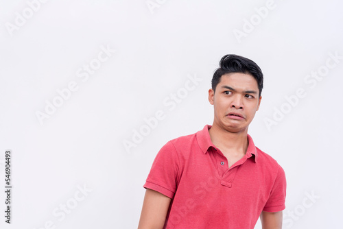 A young asian looking very disgusted, reacting to a cringe inducing situation. Feeling repulsed and grossed out. Isolated on a white backdrop.