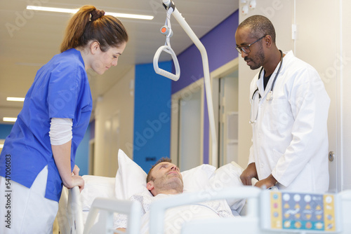 smiling woman and doctor on hospital bed transporting a patient