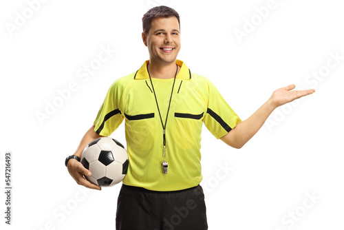 Smiling football referee showing with hand and holding a ball