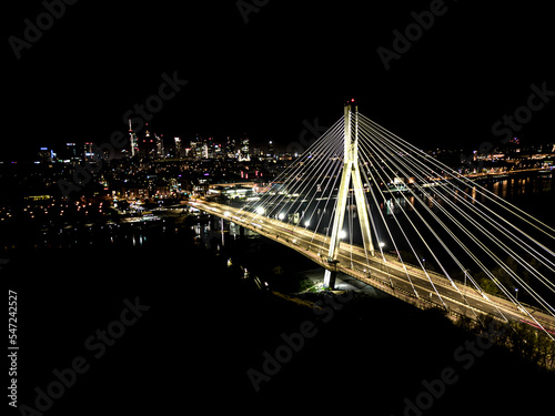 The Swietokrzyski Bridge over Vistula river, on modern cable-stayed bridge in Warsaw, Downtown. Aerial night view
