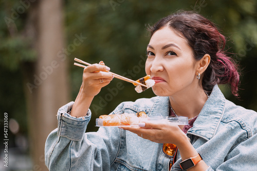 A girl sniffs spoiled seafood in her sushi snacks. The concept of food poisoning and intoxication