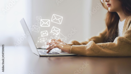 Email marketing and newsletter concept. Woman using computer laptop and sending online message with email icon