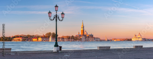 Panoramic view of San Giorgio Maggiore at sunrise with famous pink street lamp, Venice, Italy