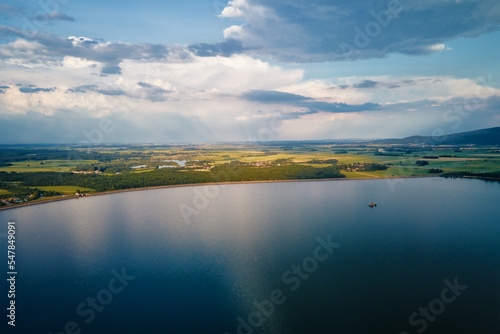 Aerial top view of beautiful landscape with large lake against mountains shapes at summer day. Mietkow lake near Wroclaw, Poland