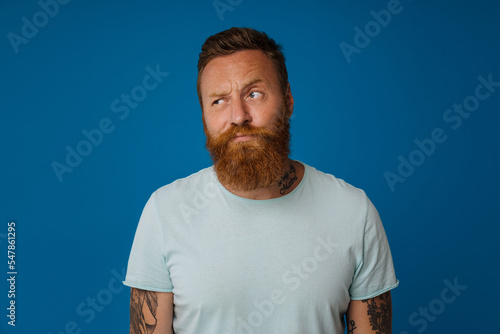 Portrait of adult bearded tattooed handsome stylish sceptic man