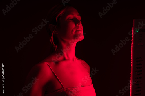 Woman getting red light therapy from a red light device