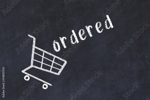 Chalk drawing of shopping cart and word ordered on black chalboard. Concept of globalization and mass consuming