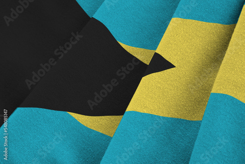 Bahamas flag with big folds waving close up under the studio light indoors. The official symbols and colors in banner