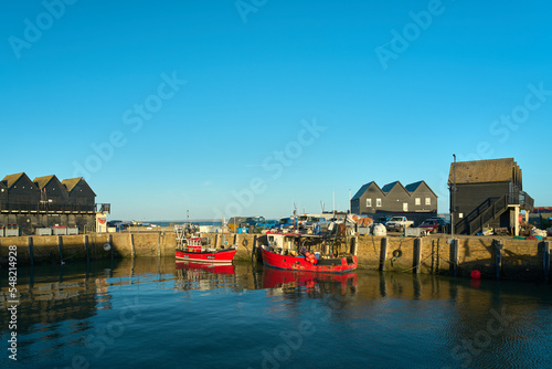 Whitstable, Kent, UK - October 6 2022 - Two red boats in Whitstable Harbour