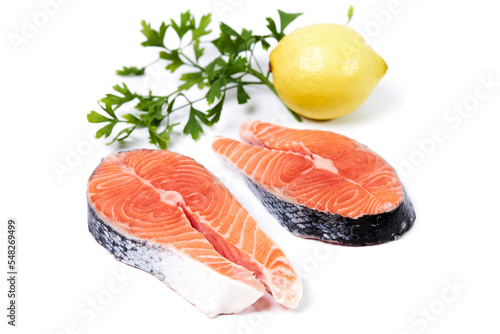Salmon, slice of fresh raw fish with parsley and lemon, isolated on white background