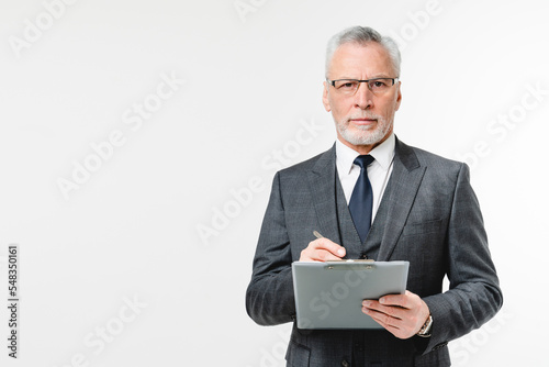 Confident caucasian mature middle-aged inspector businessman auditor advisor with clipboard writing checking info, doing paperwork in white background