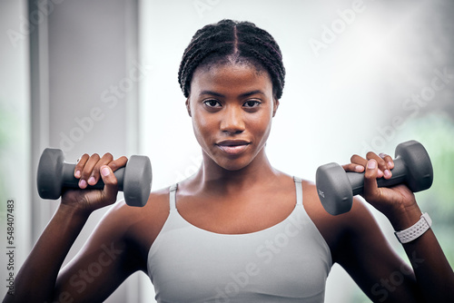 Face portrait, dumbbells and black woman training in gym for muscle, strength and power. Sports, energy and young female bodybuilder weight lifting in fitness center for wellness, workout or exercise